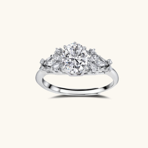 Sterling silver ring with oval moissanite center stone surrounded by smaller accent stones in ornate setting